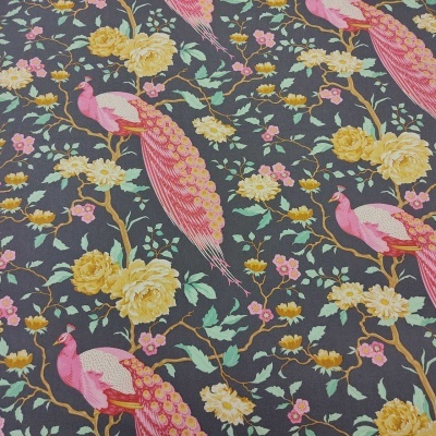 Pano com estampa de pavões cor-de-rosa e flores amarelas sobre fundo cinzento escuro