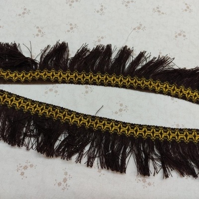 Franja decorativa castanha com padrão amarelo sobre fundo claro