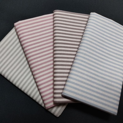 Tecido listrado em quatro cores diferentes, dobrado sobre fundo preto