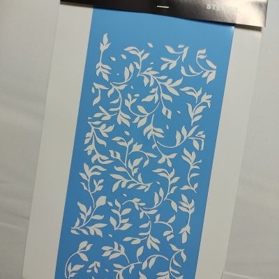 Stencil plástico azul com padrão de folhas em embalagem preto e branco