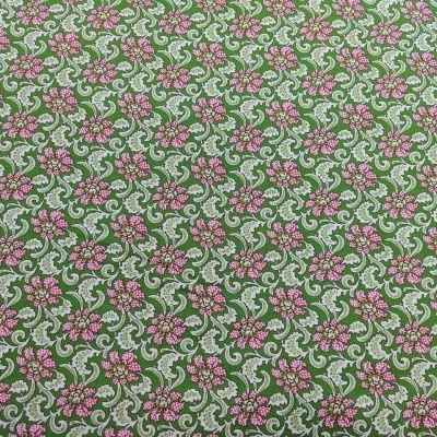 Tecido de padrão floral cor-de-rosa e folhas brancas sobre fundo verde