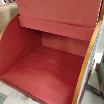 Caixa de armazenamento vermelha aberta com interior aveludado em madeira