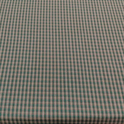 Tecido xadrez verde, branco e cinza sobre uma mesa