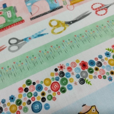 Tecido com padrões de máquinas de costura, tesouras, alfinetes, botões e flores coloridas