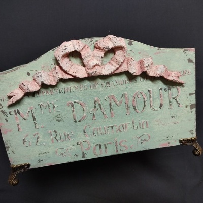 Prateleira decorativa verde claro com ornamento rosa e texto em relevo