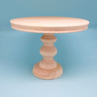 Mesa redonda de madeira clara com base esculpida