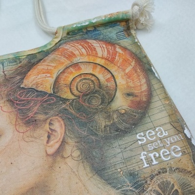 Mochila com cordões e estampa de mulher com concha do mar e texto inspirador
