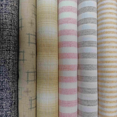 Rolos de tecido com padrões variados em tons suaves e riscas