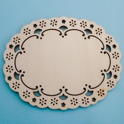 Forma ovalada de madeira clara com recortes decorativos em padrão floral sobre fundo azul