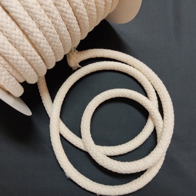 Rolo de corda branca de tecido com textura trançada em superfície preta
