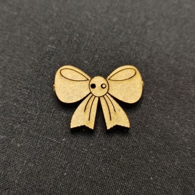 Laço de madeira claro com detalhes gravados a preto sobre tecido preto