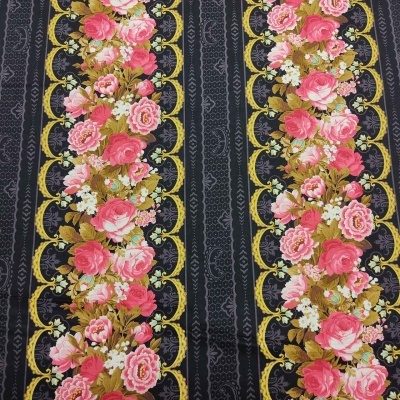 Pano com riscas pretas e douradas e bordos florais de rosas cor-de-rosa e brancas