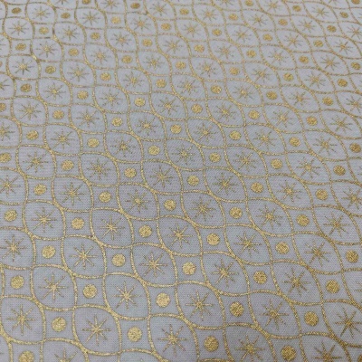 Tecido branco com padrão geométrico dourado bordado