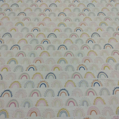 tecido branco com padrão de pequenos arcos-íris em várias cores