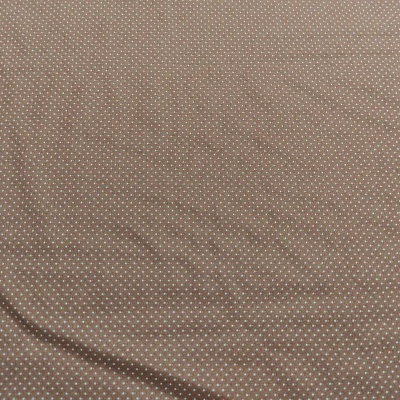 Tecido castanho claro com padrão de pequenos pontos brancos.