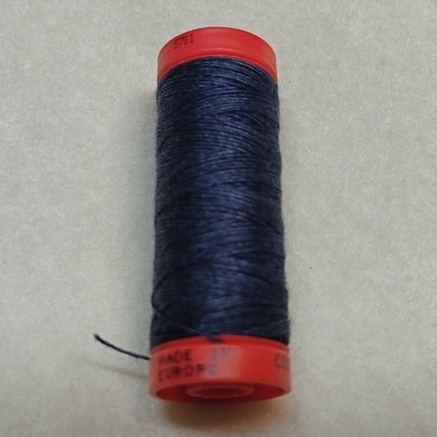 Rolo de linha azul escuro num carretel vermelho sobre superfície bege