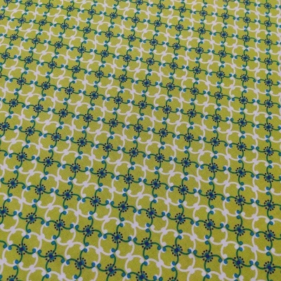 Tecido com padrão geométrico e floral amarelo, verde, azul e branco