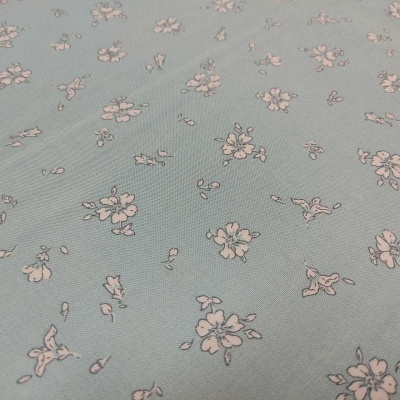Tecido azul claro com padrão floral branco
