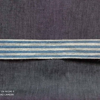 Tira têxtil riscada azul sobre tecido escuro