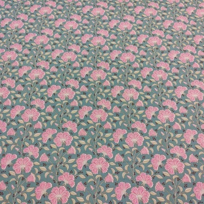 Tecido com flores rosa e folhas verdes sobre fundo cinza azulado