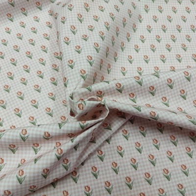 Tecido branco com padrão de flores cor-de-rosa e folhas verdes