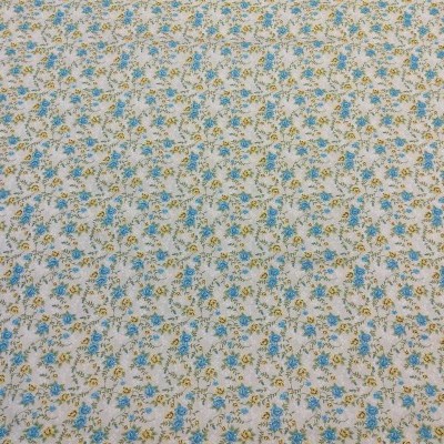 Tecido de algodão com padrão floral em azul, amarelo e verde sobre fundo branco