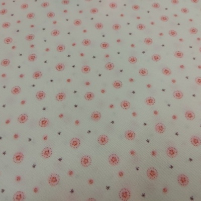 Tecido branco com padrão floral vermelho e estrelas castanhas