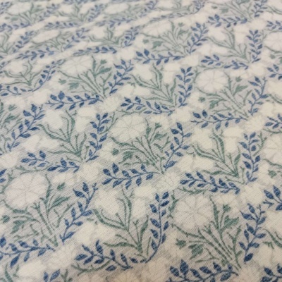 Pano branco com padrão de ramos azuis e verdes