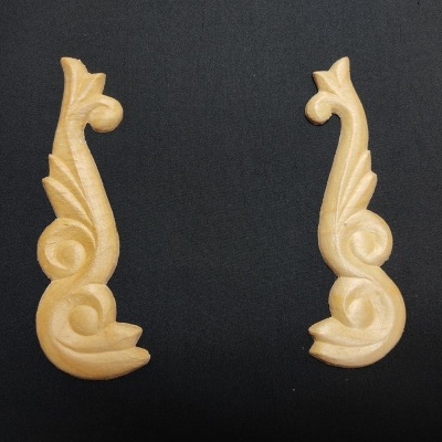 Dois apliques decorativos em madeira clara com padrão de folhas