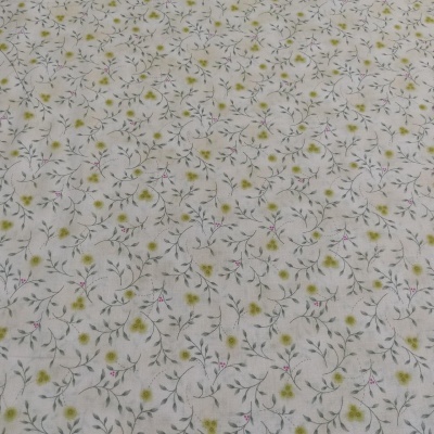 Tecido branco com padrão floral delicado em verde, amarelo e rosa.