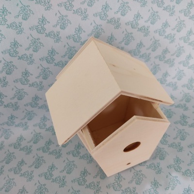 Ninho de pássaro em madeira clara com orifício circular