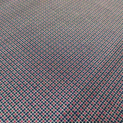 Tecido geométrico azul, vermelho e branco com padrão de losangos