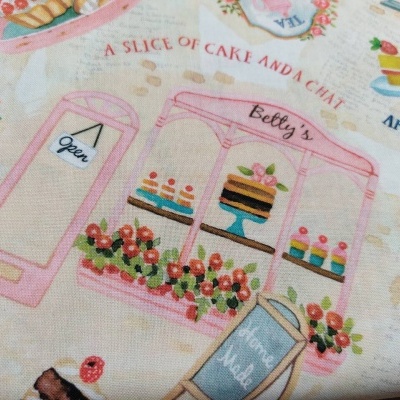 Tecido com padrão colorido ilustrando uma pastelaria e bolos