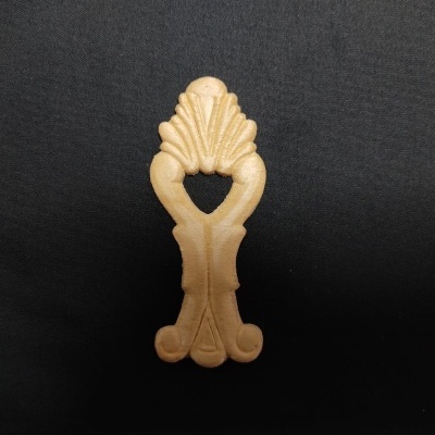 Peça decorativa em madeira clara com detalhes curvos sobre fundo preto