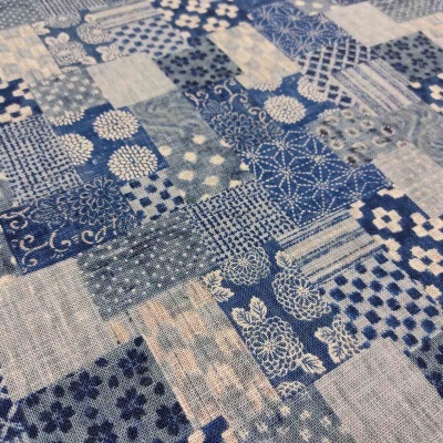 Tecido patchwork com padrões florais, geométricos e bolinhas em azul e branco.