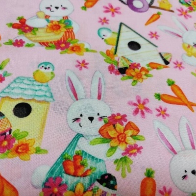 tecido rosa com padrão de coelhos, casas de pássaros, cenouras e flores