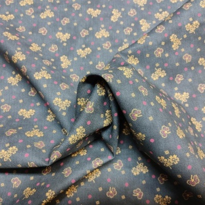 tecido verde-acinzentado com padrão de pequenas flores amarelas e rosas