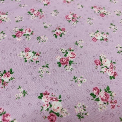 Tecido lilás com estampa floral de rosas em rosa, vermelho e branco com folhas verdes