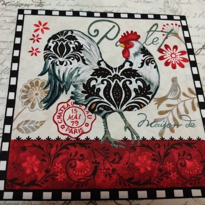 Pano com estampa de galo colorido e texto em fundo claro com moldura quadriculada