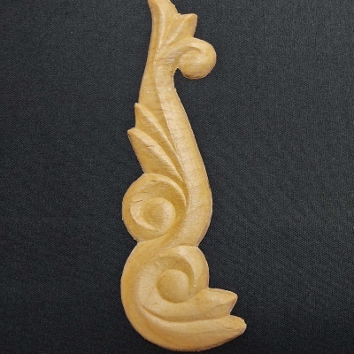 Peça decorativa de madeira entalhada clara com padrão espiral e folhas