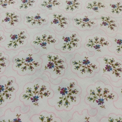 Tecido branco com padrão floral colorido e linhas onduladas cor-de-rosa.