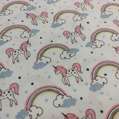 Tecido branco com padrão de unicórnios cor-de-rosa, estrelas, nuvens azuis e arco-íris