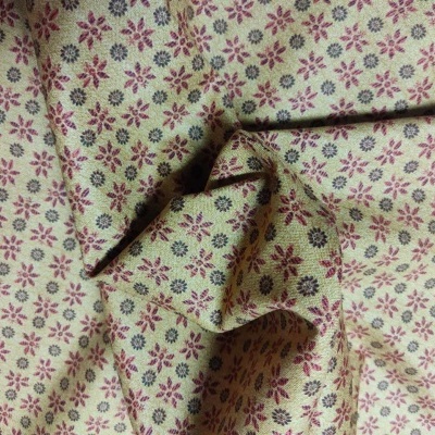 tecido bege com padrão floral pequeno vermelho e roxo dobrado