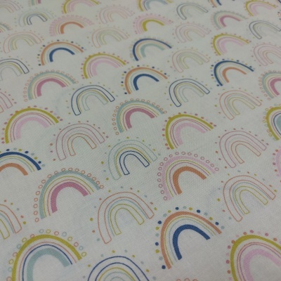 Tecido branco com estampado de arcos-íris coloridos e padrões de pontos
