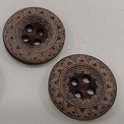 Dois botões de madeira gravados em padrão geométrico