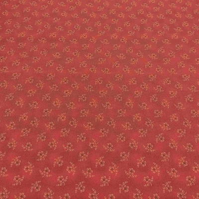 tecido vermelho com padrão de pequenas flores douradas e verdes
