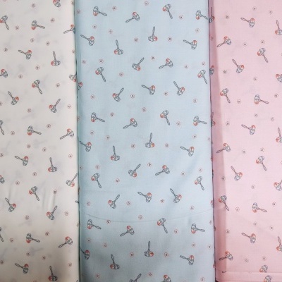 três tecidos com padrão de baldes e pás em branco, azul claro e rosa