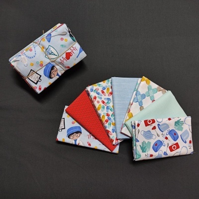 Conjunto de tecidos dobrados com diversos padrões coloridos sobre fundo preto