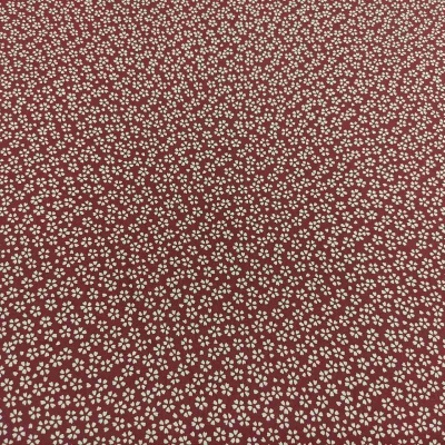 Tecido vermelho com padrão de pequenas flores brancas