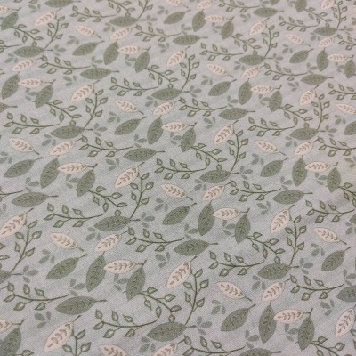 tecido com padrão de folhas verdes e bege em fundo cinza claro